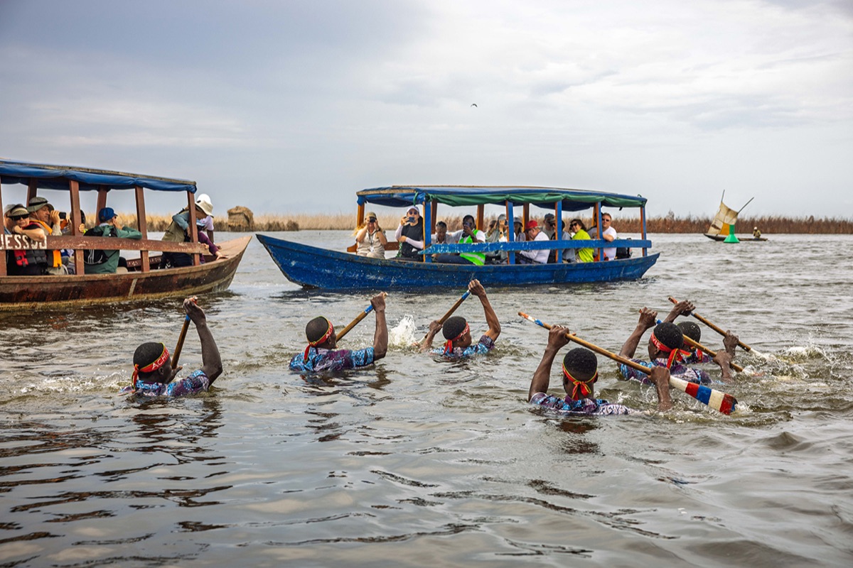 Swan Hellenic guests on boats at the lake village of Ganvié, Benin